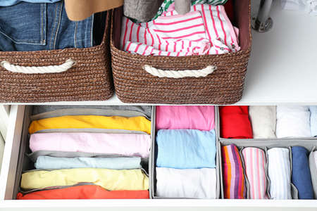 Organizers with clean clothes in closet