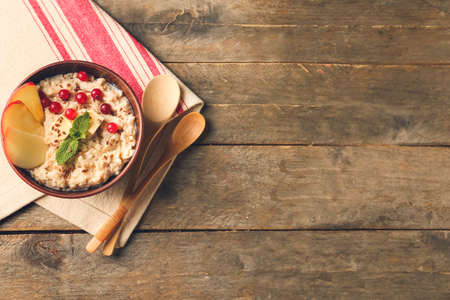Bowl with tasty sweet oatmeal on table