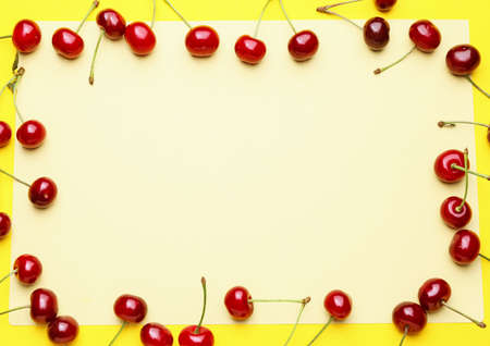 Frame made of sweet cherry on color backgroundの写真素材