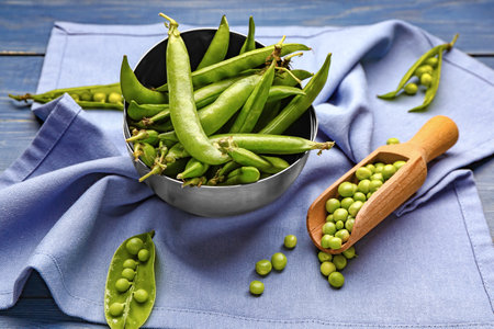 Bowls and scoop with tasty fresh peas on tableの写真素材