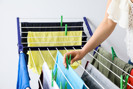 Woman hanging clean clothes on dryer, closeupの写真素材