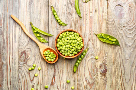 Bowl and spoon with tasty fresh peas on tableの写真素材