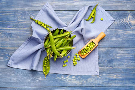 Bowl and scoop with tasty fresh peas on table