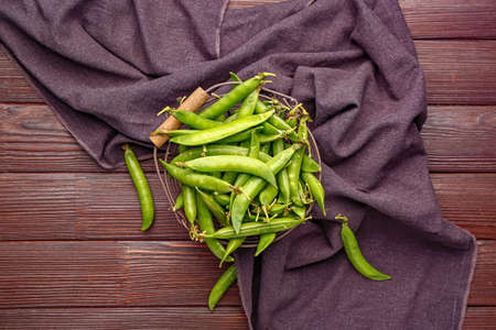Basket with tasty fresh peas on table