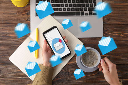 Woman using cellphone to check an email at workplaceの写真素材