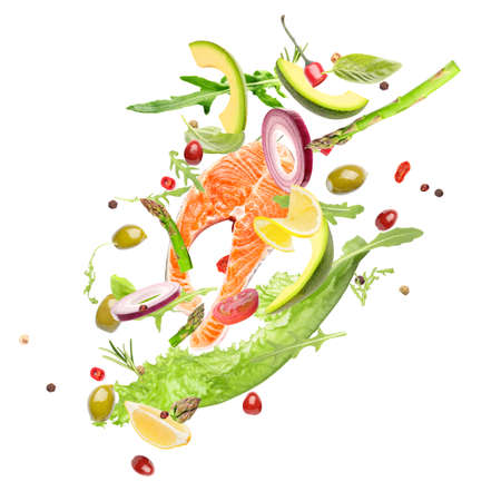 Flying ingredients for healthy salad with salmon on white backgroundの写真素材