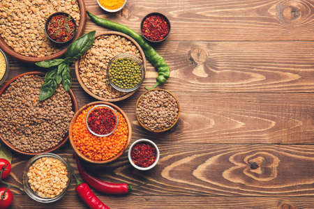 Different raw legumes with spices on tableの写真素材