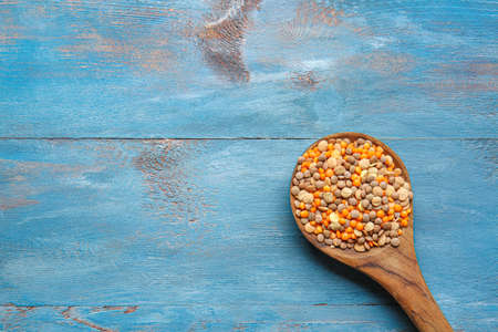 Spoon with raw lentils on tableの写真素材
