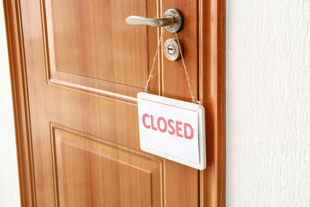 Board with word CLOSED hanging on door indoorsの写真素材