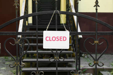 Board with word CLOSED hanging on fence outdoorsの写真素材