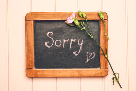 Chalkboard with word SORRY on table