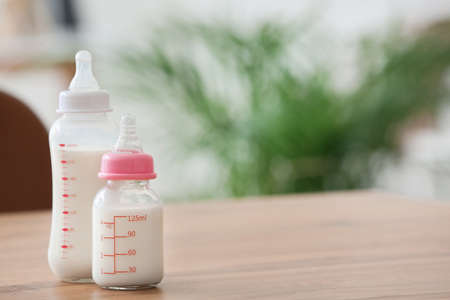 Bottles of milk for baby on table in roomの写真素材