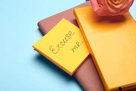 Notebooks and papers with text EXCUSE ME on color background