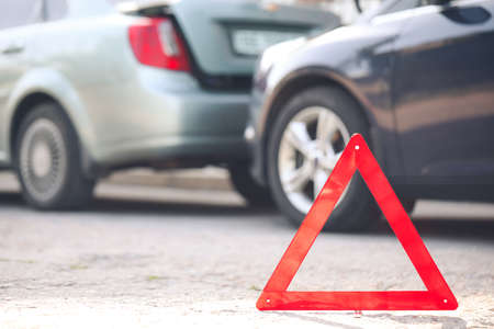 Emergency stop sign near broken cars after accident on road