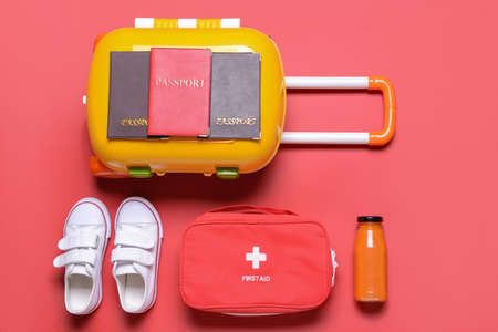 Suitcase with travel accessories for children on color backgroundの写真素材