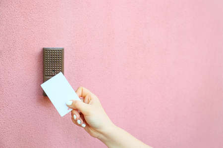 Woman using card to open door outdoorsの写真素材