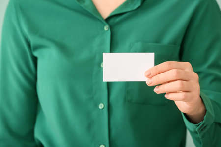Woman with blank business card, closeup