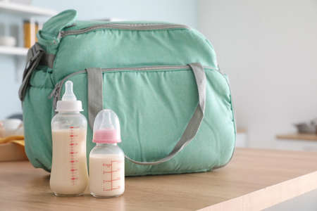Bag and bottles of milk for baby on tableの写真素材