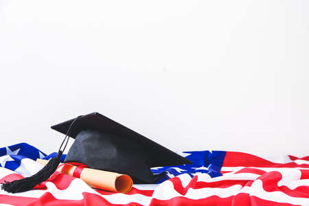 Graduation hat, USA flag and diploma on white backgroundの写真素材