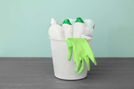 Bucket with set of cleaning supplies on tableの写真素材