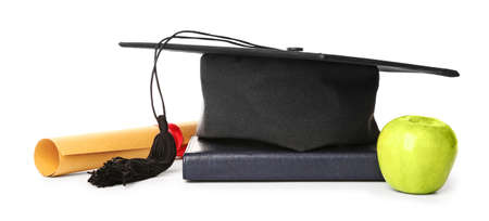 Graduation hat, diploma, apple and book on white backgroundの写真素材