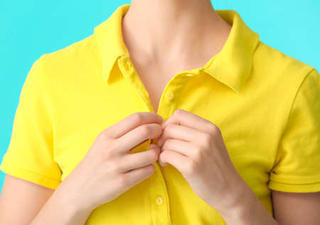 Beautiful young woman in stylish polo shirt on color background