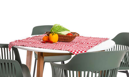 Basket with fresh vegetables on table against white backgroundの写真素材