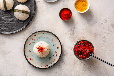 Traditional Japanese onigiri with spices on light background