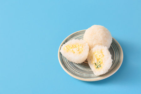 Plate with traditional Japanese onigiri on color backgroundの写真素材