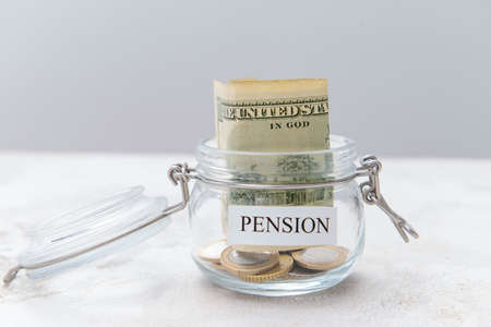 Jar with savings on table. Concept of pensionの写真素材