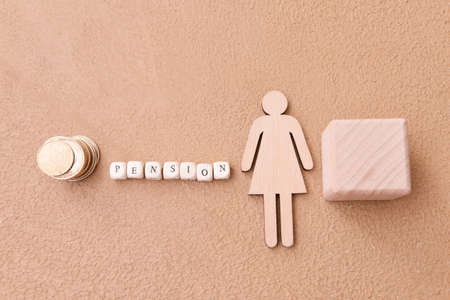 Female figure with coins and word PENSION on color backgroundの写真素材