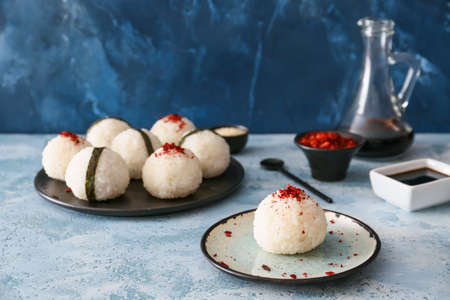 Traditional Japanese onigiri with spices on color backgroundの写真素材