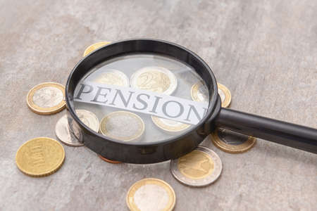 Word PENSION with coins and magnifier on gray backgroundの写真素材