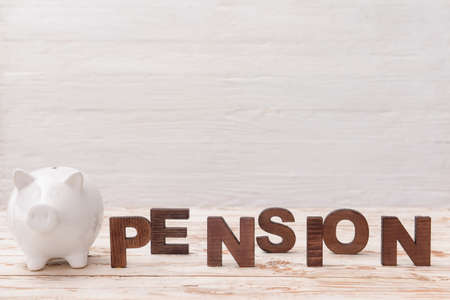 Word PENSION with piggy bank on white wooden backgroundの写真素材
