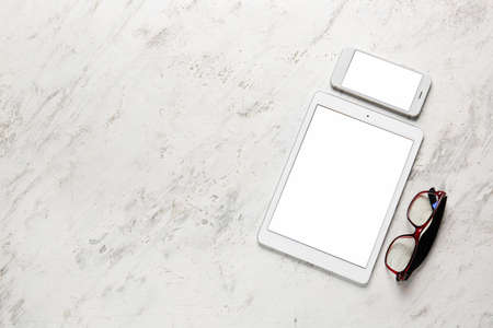 Modern tablet computer, cellphone and glasses on light backgroundの写真素材