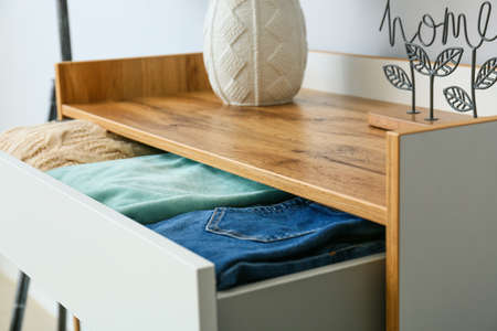 Modern chest of drawers with clothes in room, closeupの写真素材