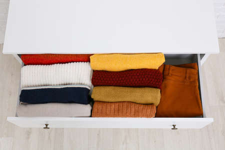 Modern chest of drawers with clothes in room, top viewの写真素材