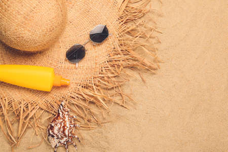 Beach accessories on sand background