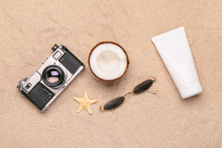 Summer composition with beach accessories and photo camera on sand backgroundの写真素材