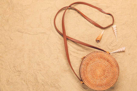 Stylish female bag on sand background