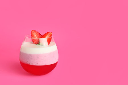 Tasty strawberry dessert in glass on color backgroundの写真素材