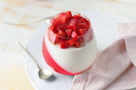 Tasty strawberry dessert in glass on table