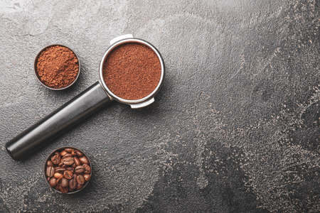 Portafilter with coffee powder and beans on dark backgroundの写真素材