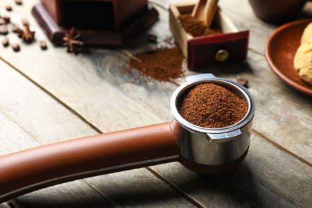 Portafilter with coffee powder on wooden backgroundの写真素材