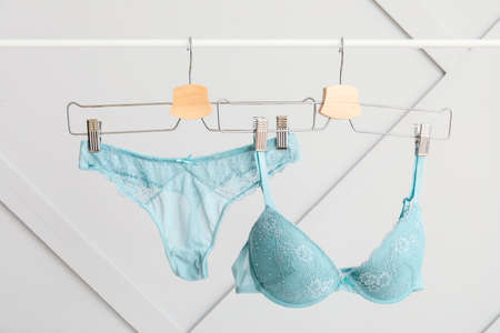 Hangers with stylish female lingerie on gray backgroundの写真素材