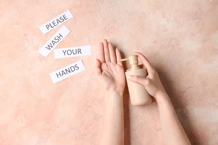 Text PLEASE WASH YOUR HANDS and woman applying liquid soap on her hand against color background, top...