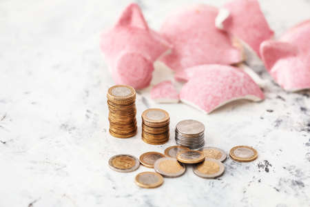 Broken piggy bank and money on tableの写真素材