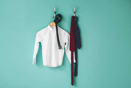 Stylish school uniform hanging on color wallの写真素材