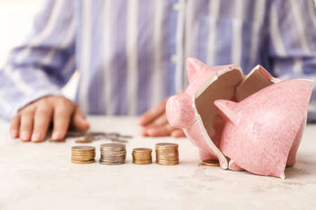 Woman counting money after breaking piggy bankの写真素材