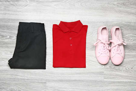 Stylish school uniform on wooden background
